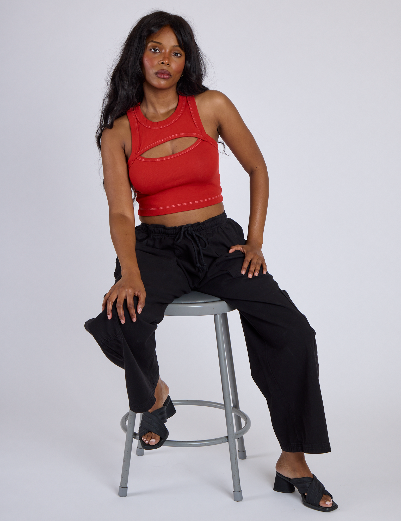 Kandia is wearing Porthole Tank in Mustang Red and Black Drop Pocket Cargo Pants