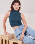 Alex is wearing Sleeveless Essential Turtleneck in Lagoon and light wash Trouser Jeans