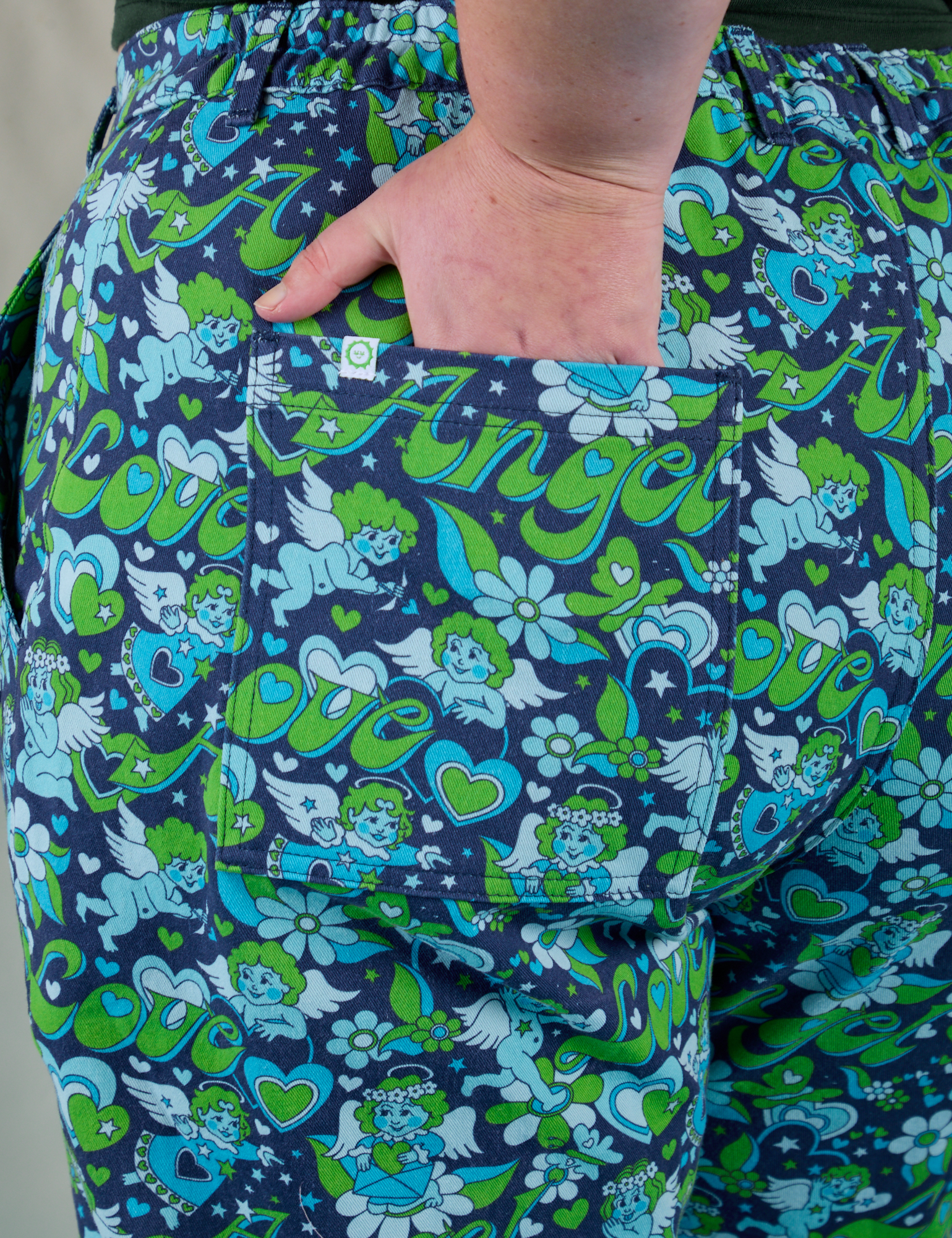 Close up of Juliet's hand in the back pocket of Work Pants in Angel Print