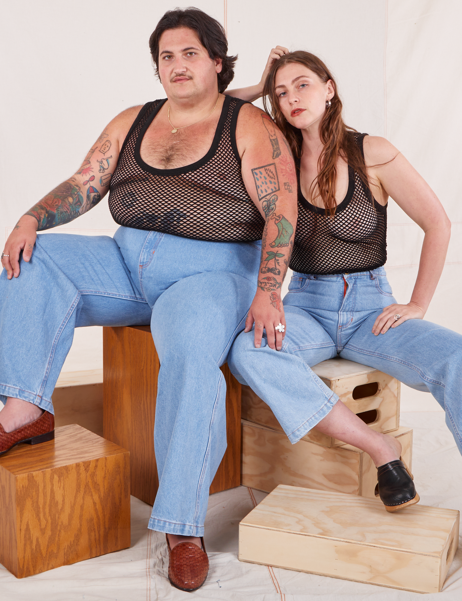 Sam and Allison are both wearing Mesh Tank Top in Basic Black and light wash Sailor Jeans