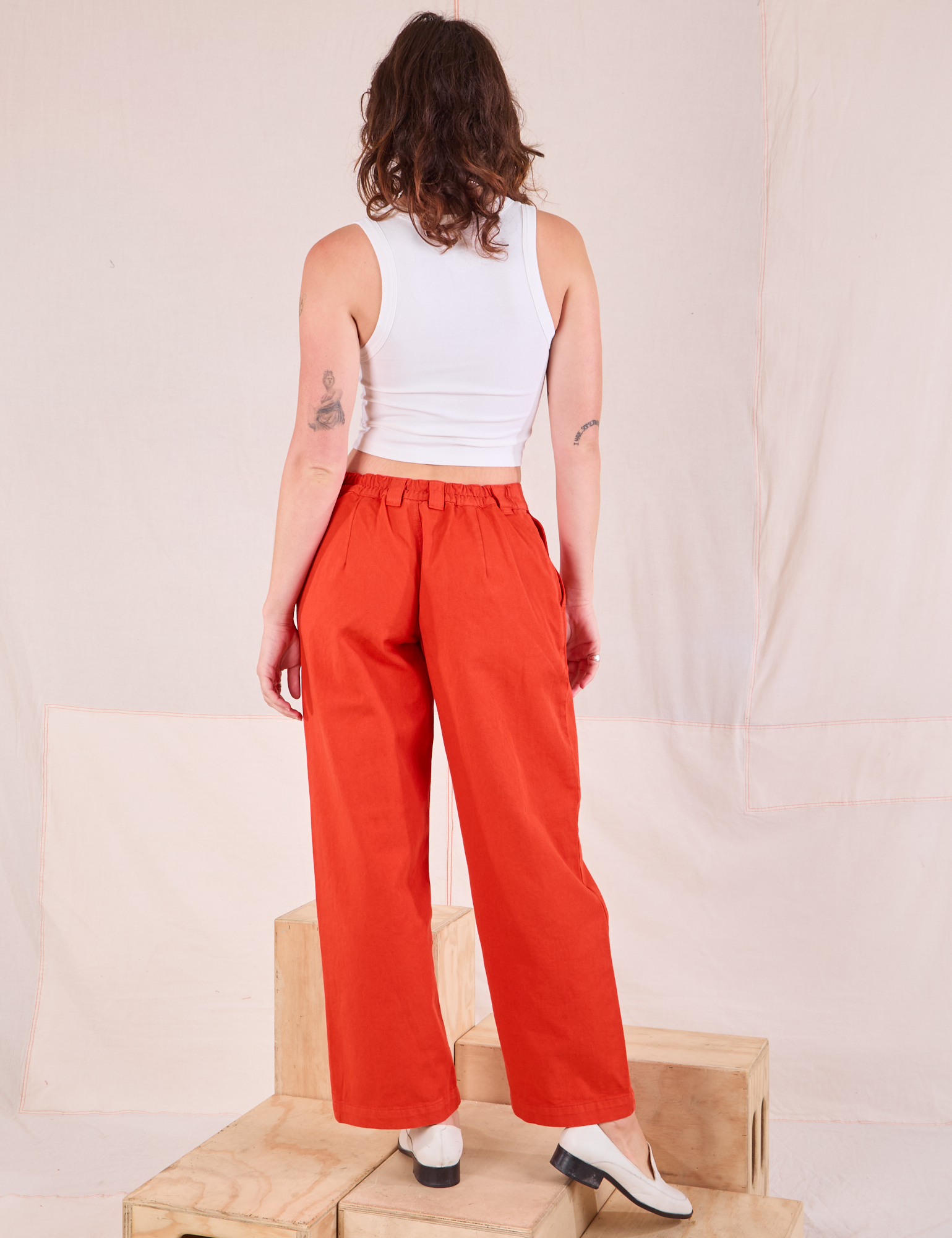 Back view of Mid-Rise Pleated Trousers in Chili Red and Cropped Tank in vintage tee off-white worn by Alex