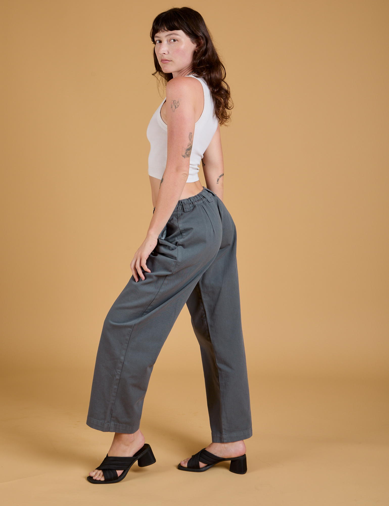 Side view of Baggy Mid-Rise Trousers in Slate Grey and vintage tee white Cropped Tank on Alex