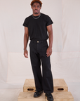 Issac is 5'10" and wearing M Mid-Rise Work Pants in Basic Black paired with black Organic Vintage Tee