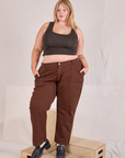 Juliet is 5'7" and wearing 2XL Mid-Rise Work Pants in Fudgesicle Brown paired with espresso brown Cropped Tank