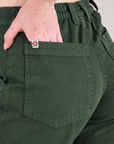 Mid-Rise Work Pants in Swamp Green close up of Margaret's hand tucked into back pocket