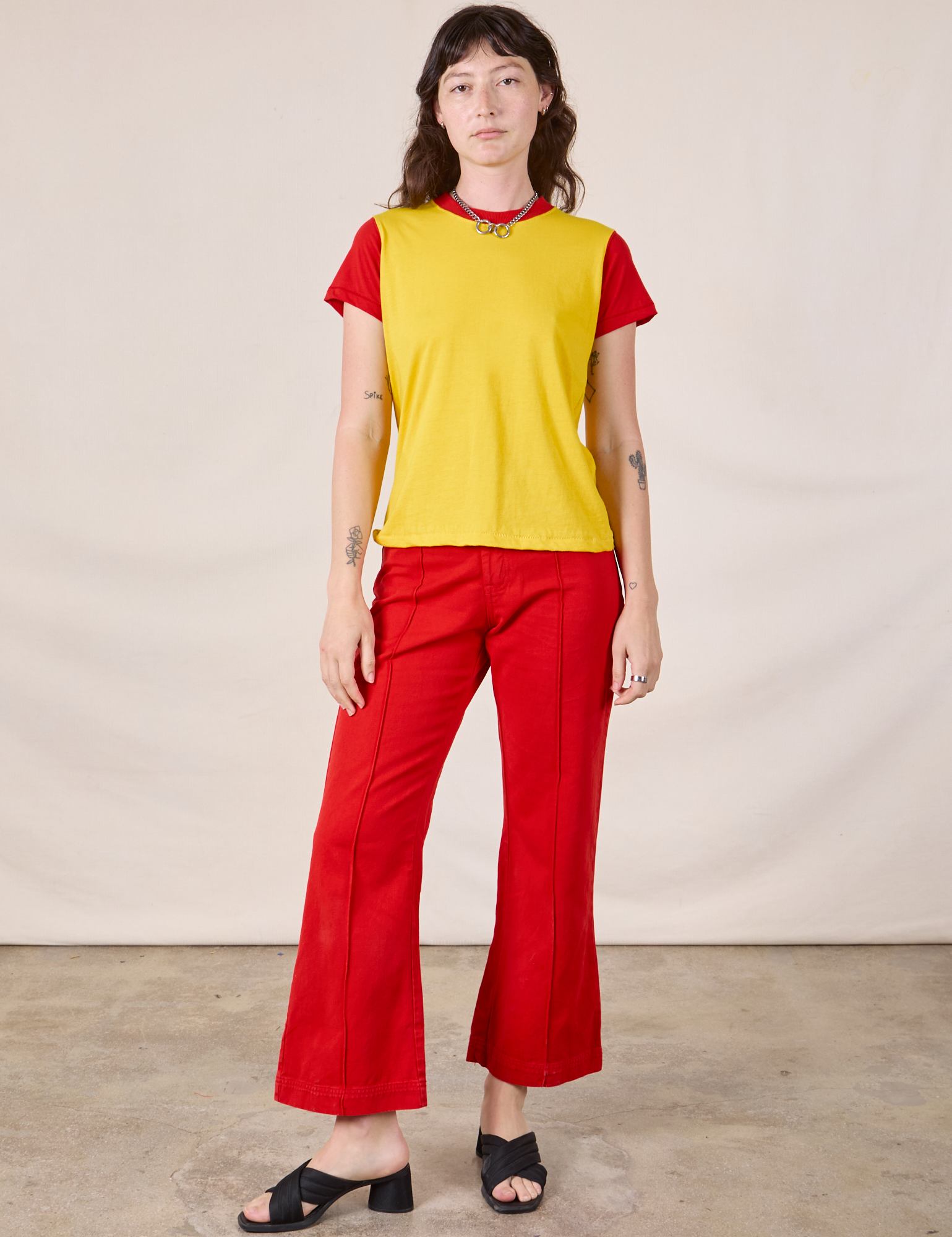 Alex is wearing Mismatched Tee in Yellow &amp; Red and mustang red Western Pants
