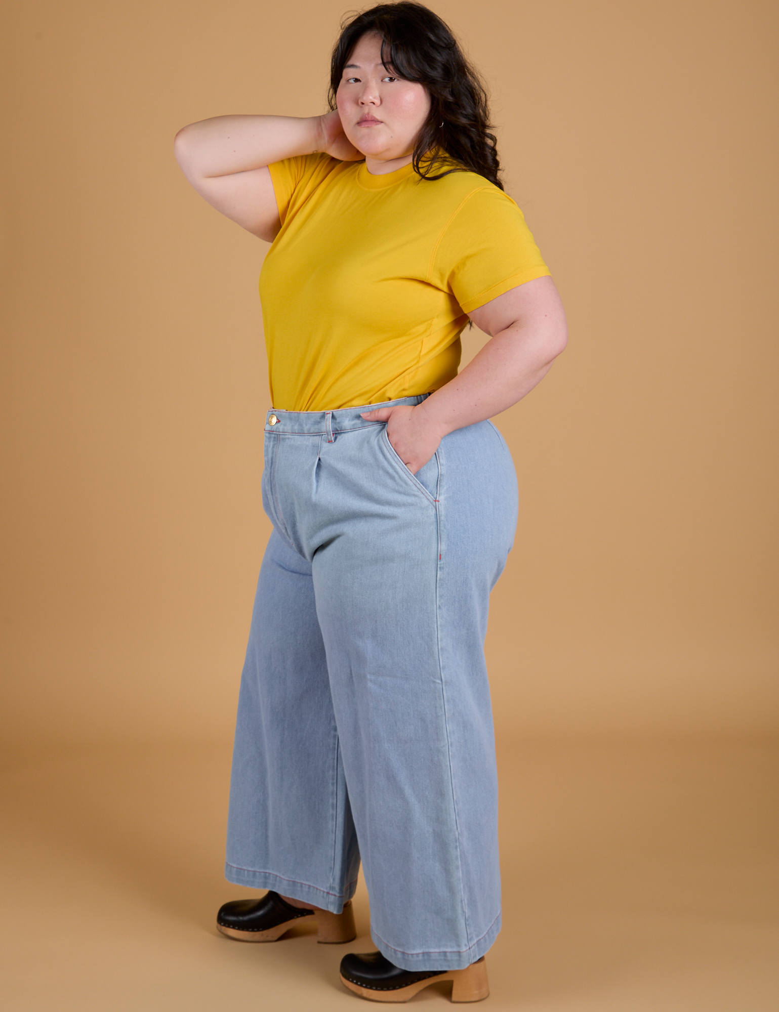 Angled front view of Organic Vintage Tee in Sunshine Yellow and light wash Indigo Wide leg Trousers on Ashley