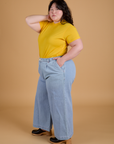 Angled front view of Organic Vintage Tee in Sunshine Yellow and light wash Indigo Wide leg Trousers on Ashley