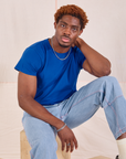 Issac is wearing Organic Vintage Tee in Royal Blue and light wash Carpenter Jeans