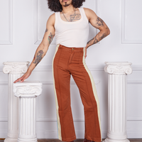 Jesse is 5'8" and wearing XS Hand-Painted Stripe Western Pants in Burnt Terracotta paired with a vintage off-white Tank Top