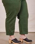 Close up side view of pant leg of Petite Short Sleeve Jumpsuit in Dark Emerald Green worn by Ashley