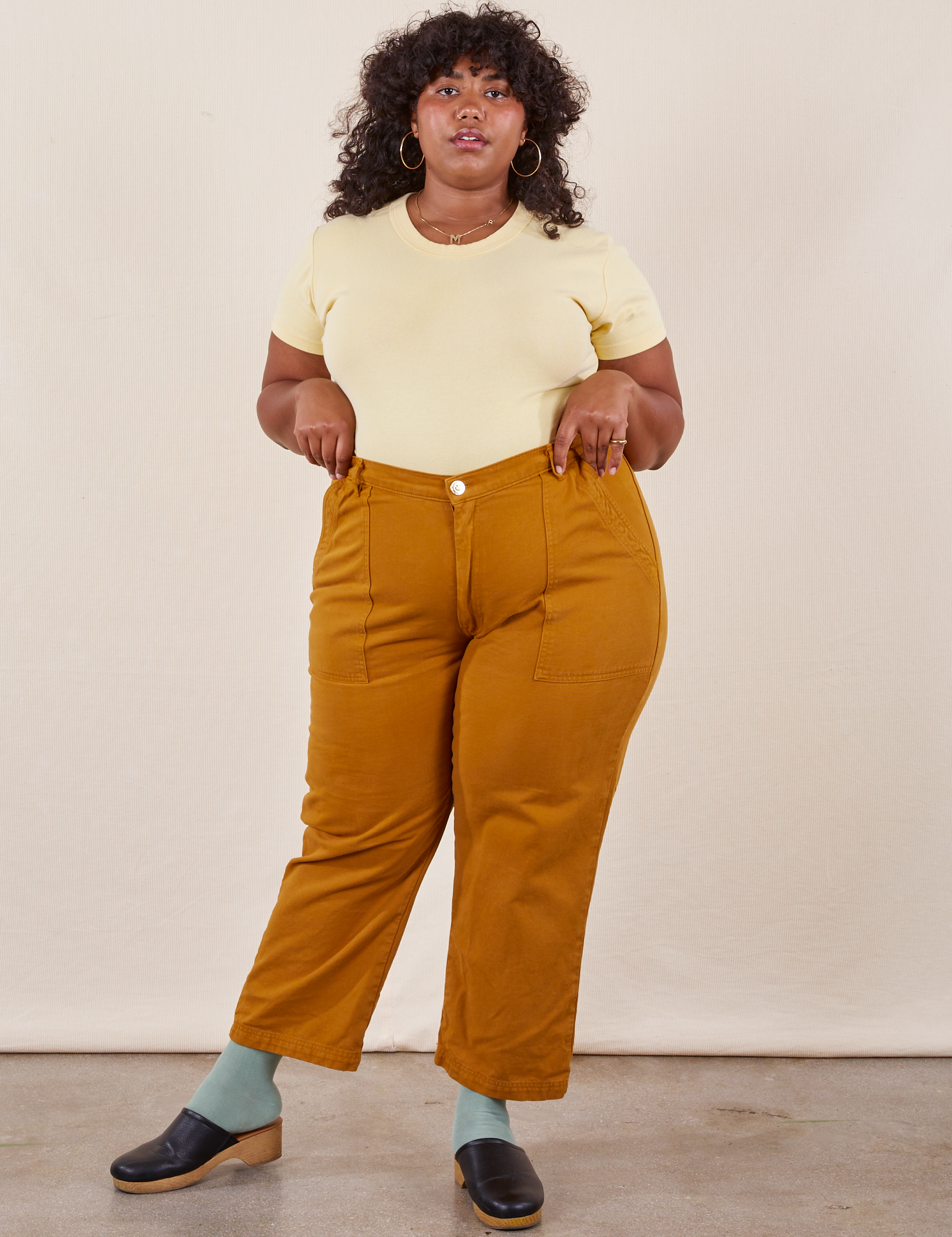 Morgan is 5&#39;5&quot; and wearing Petite 1XL Work Pants in Spicy Mustard paired with butter yellow Baby Tee