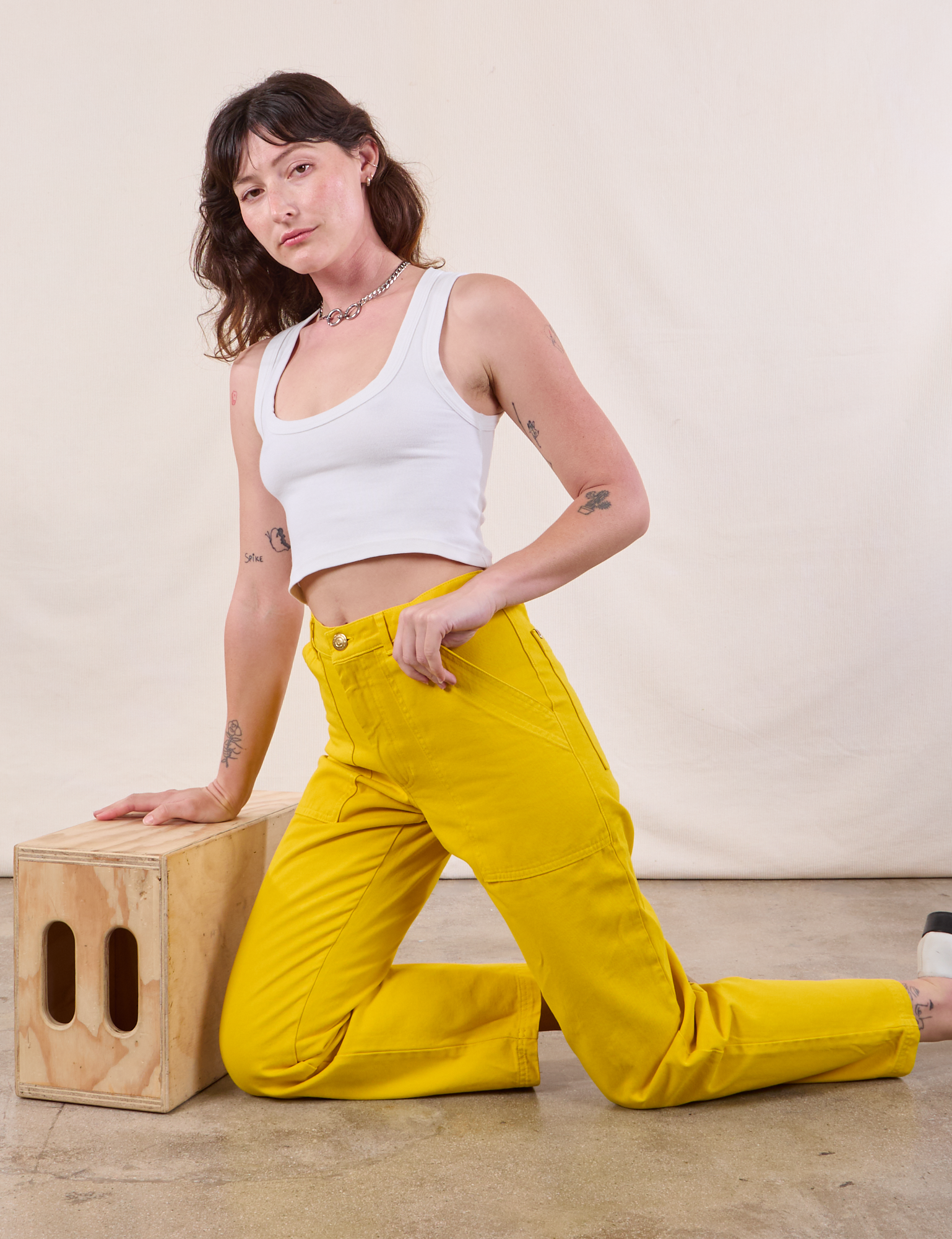 Alex is wearing Work Pants in Golden Yellow and Cropped Tank in Vintage Tee Off-White