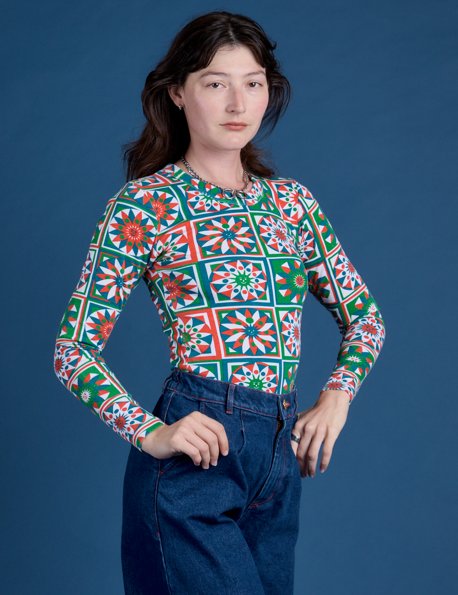 Angled front view of Long Sleeve Baby Tee in Quilt Print on Alex