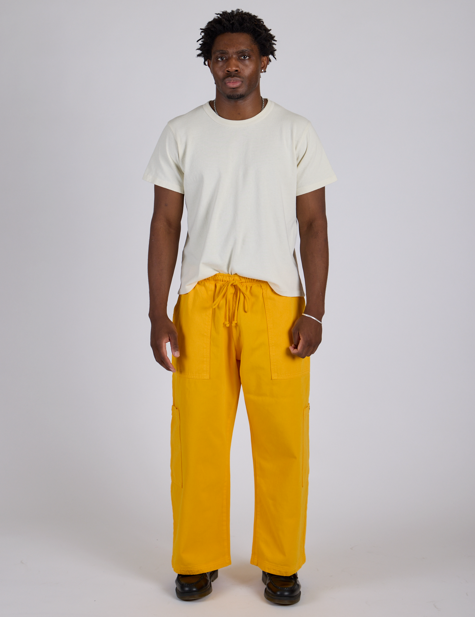 Isaac is 5’10” and wearing M Drop Pocket Cargo Pants in Sunshine Yellow paired with Organic Vintage Tee in Vintage Tee White