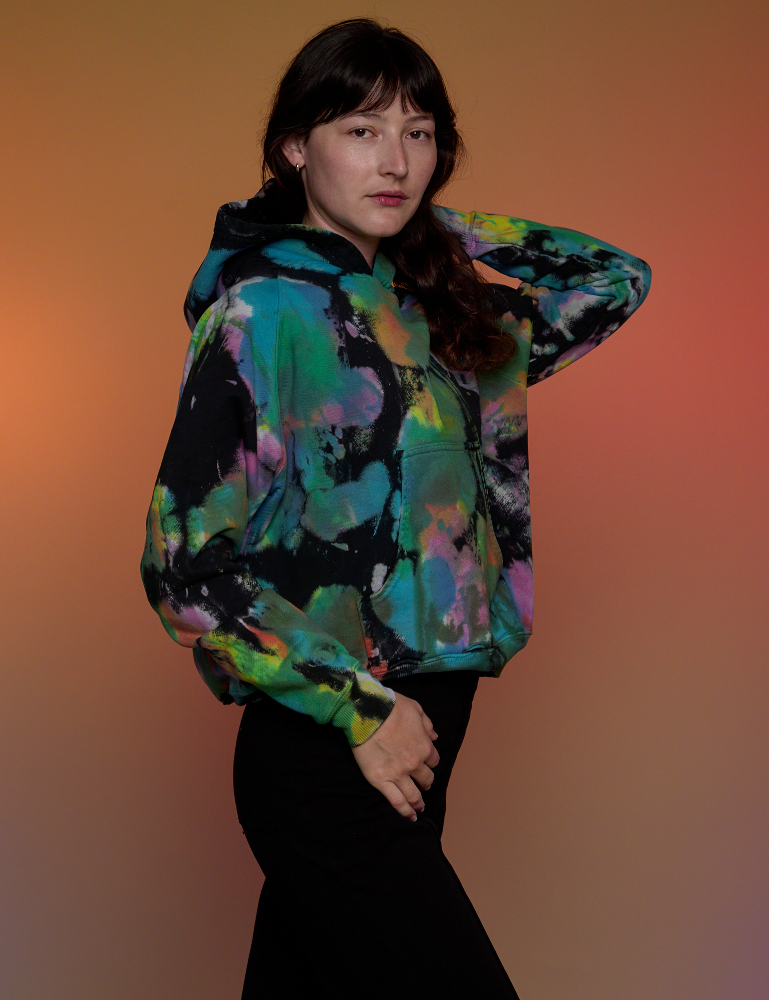 Angled front view of Oversized Hoodie in Rainbow Magic Waters on Alex