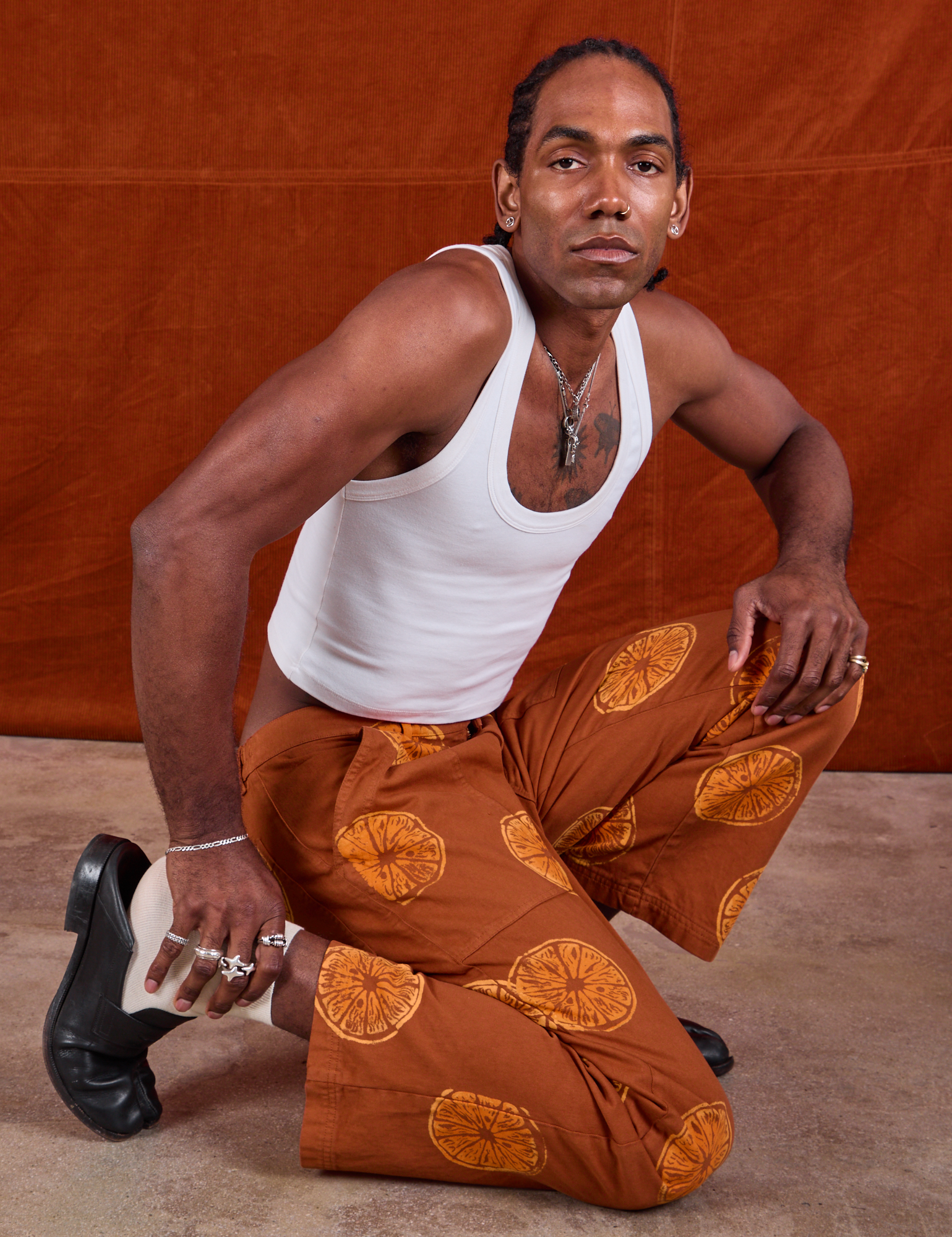 Jerrod is wearing Paintstamped Work Pants in Orange and Cropped Tank in Vintage Tee Off-White