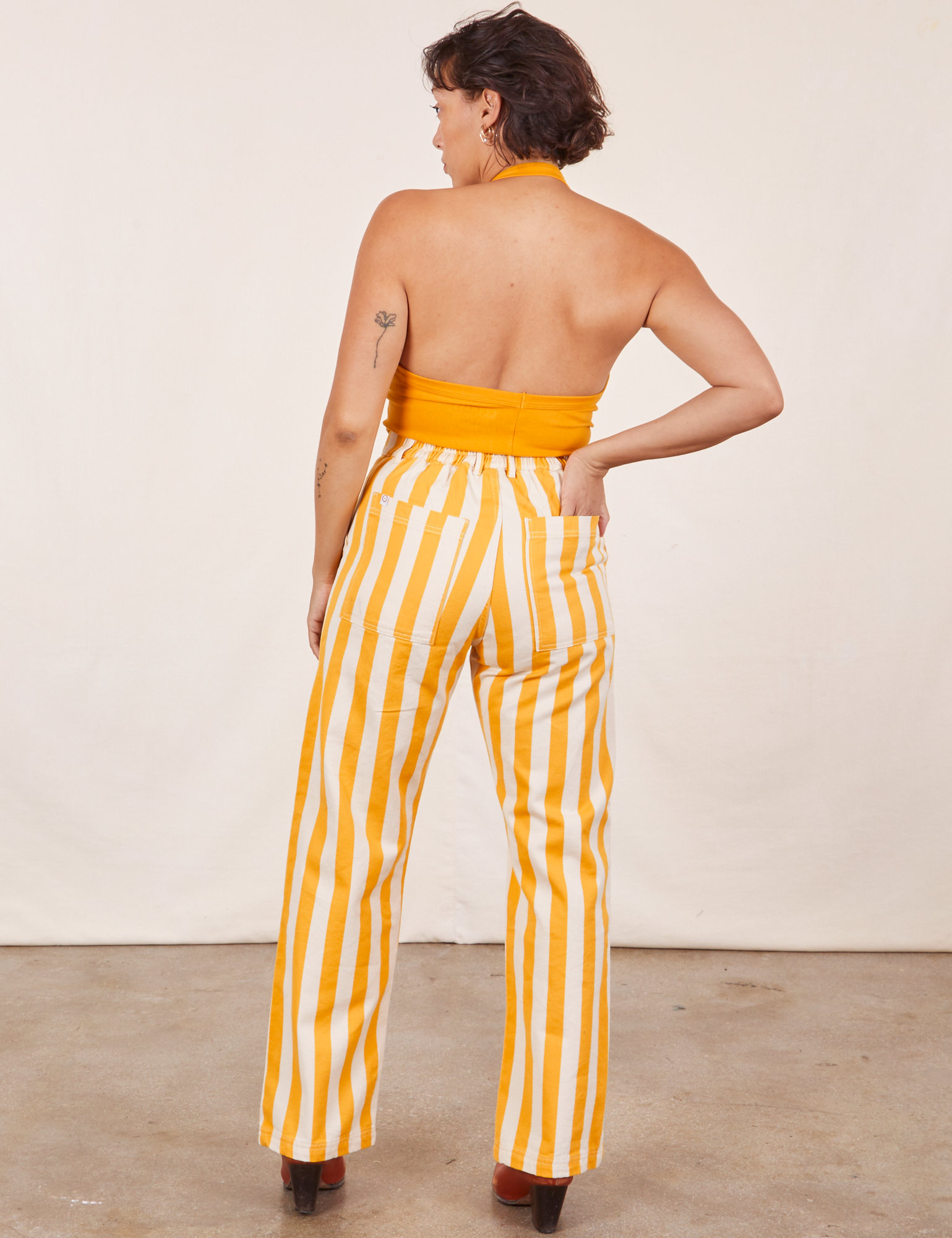 Back view of Work Pants in Lemon Stripe and mustard yellow Halter Top on Tiara