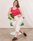 Allison is sitting in a green chair wearing a Tank Top in Hot Pink paired with vintage off-white Western Pants