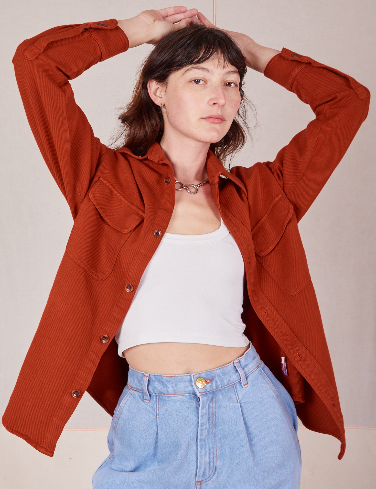 Alex is wearing Flannel Overshirt in Paprika, vintage off-white Cropped Tank Top and light wash Trouser Jeans