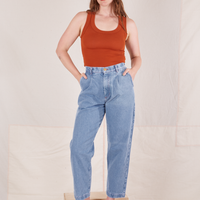 Allison is 5'10" and wearing XS Denim Trouser Jeans in Light Wash paired with a burnt orange Tank Top