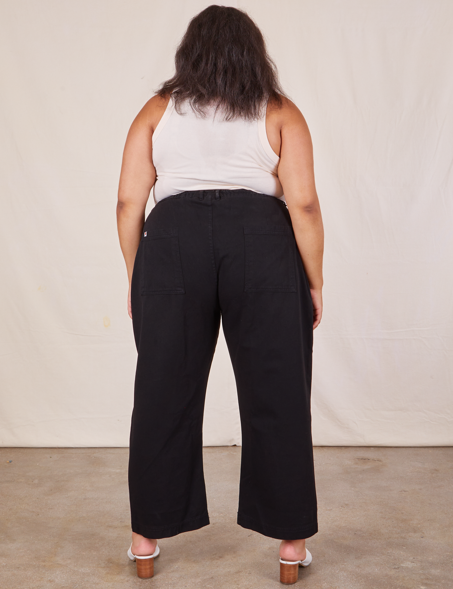 Back view of Western Pants in Basic Black and vintage off-white Tank Top worn by Alicia