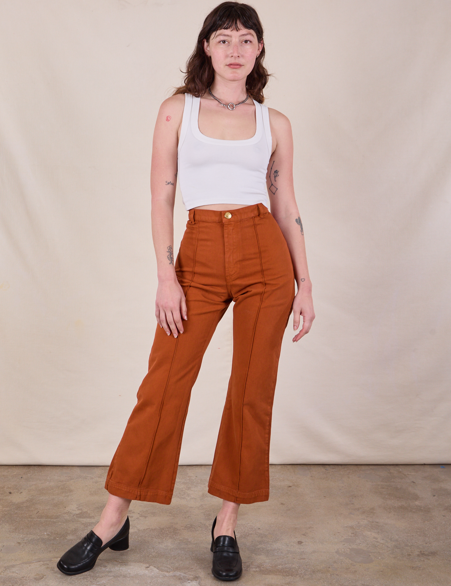 Alex is 5&#39;8&quot; and wearing XS Western Pants in Burnt Terracotta paired with a Cropped Tank in Vintage Tee Off-White