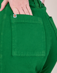 Close up of Alex's hand in the back pocket of Western Pants in Forest Green