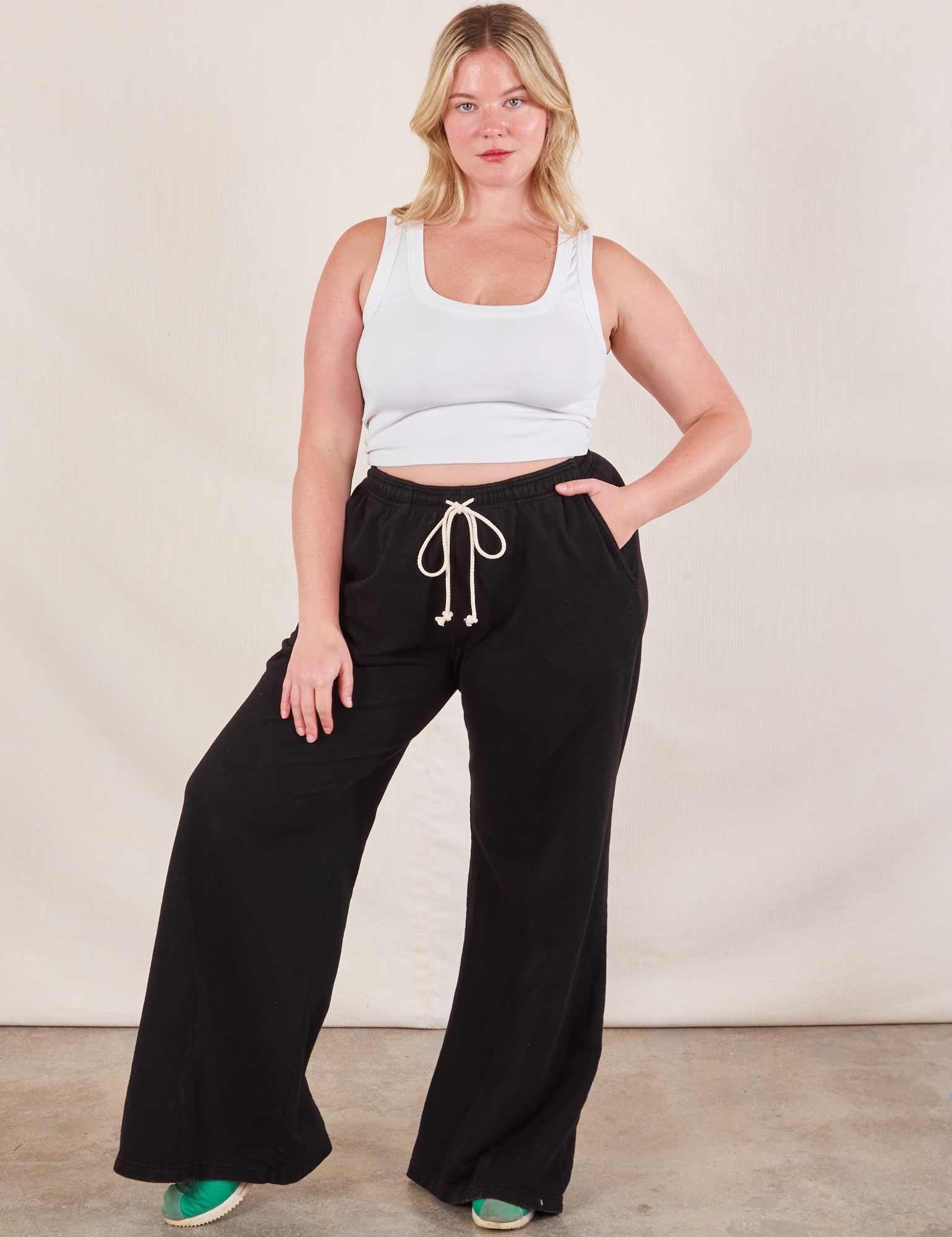 Lish is 5&#39;8&quot; and wearing M Wide Leg Sweat Pants in Basic Black paired with a Cropped Tank in vintage tee off-white