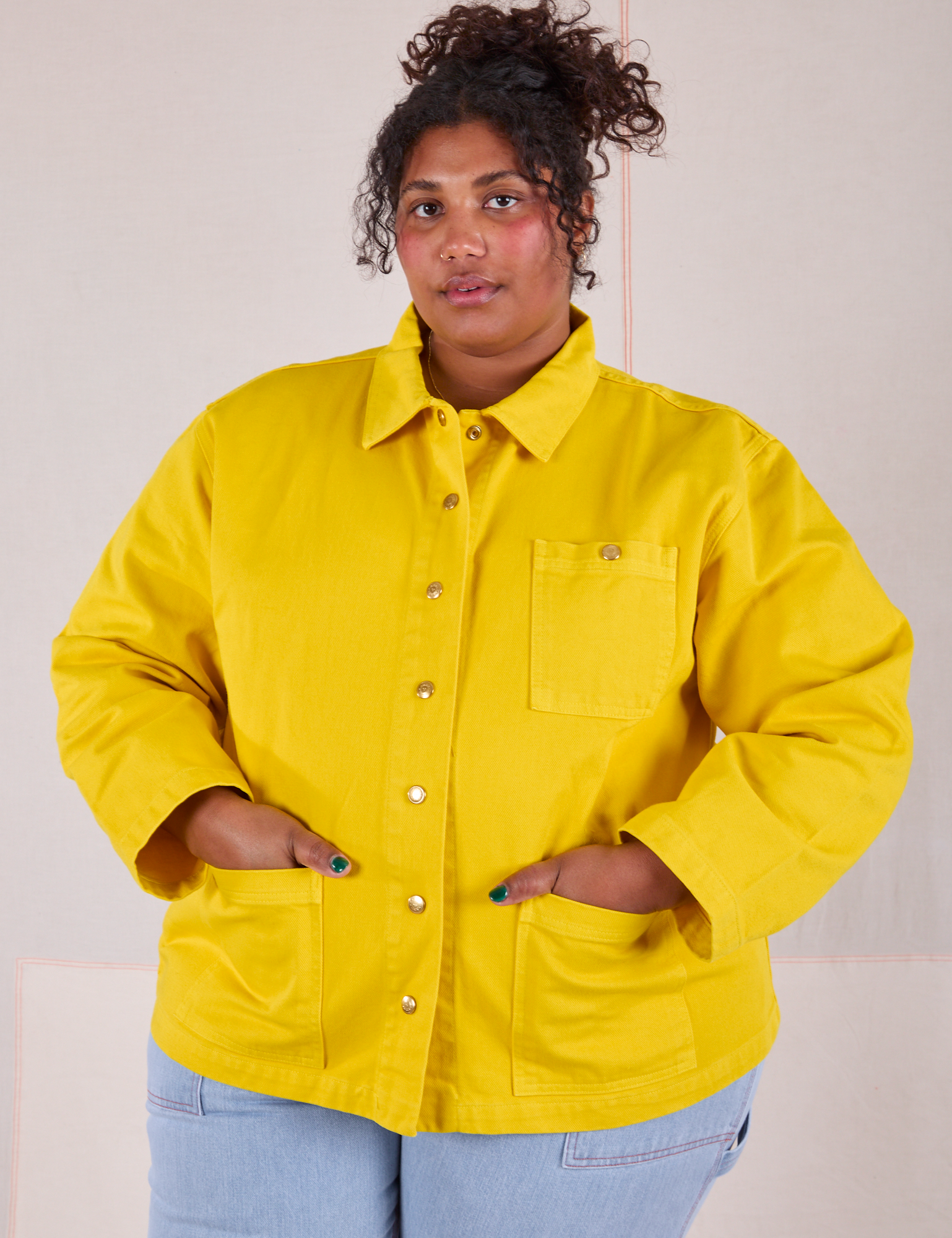 Morgan is wearing a buttoned up Denim Work Jacket in Golden Yellow