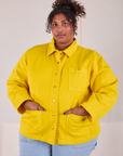 Morgan is wearing a buttoned up Denim Work Jacket in Golden Yellow