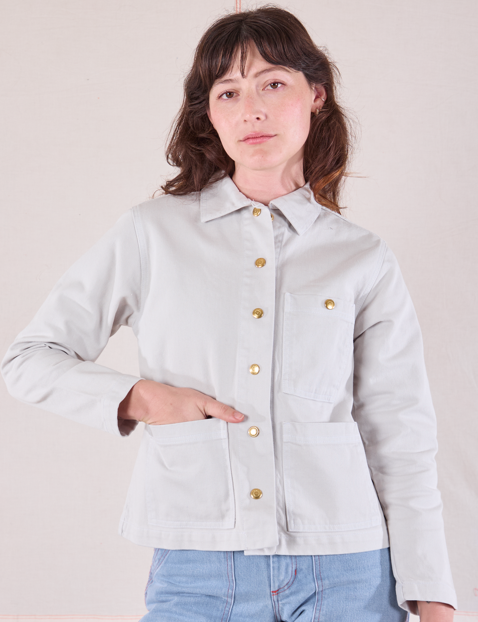 Alex is wearing a buttoned up Denim Work Jacket in Stone White