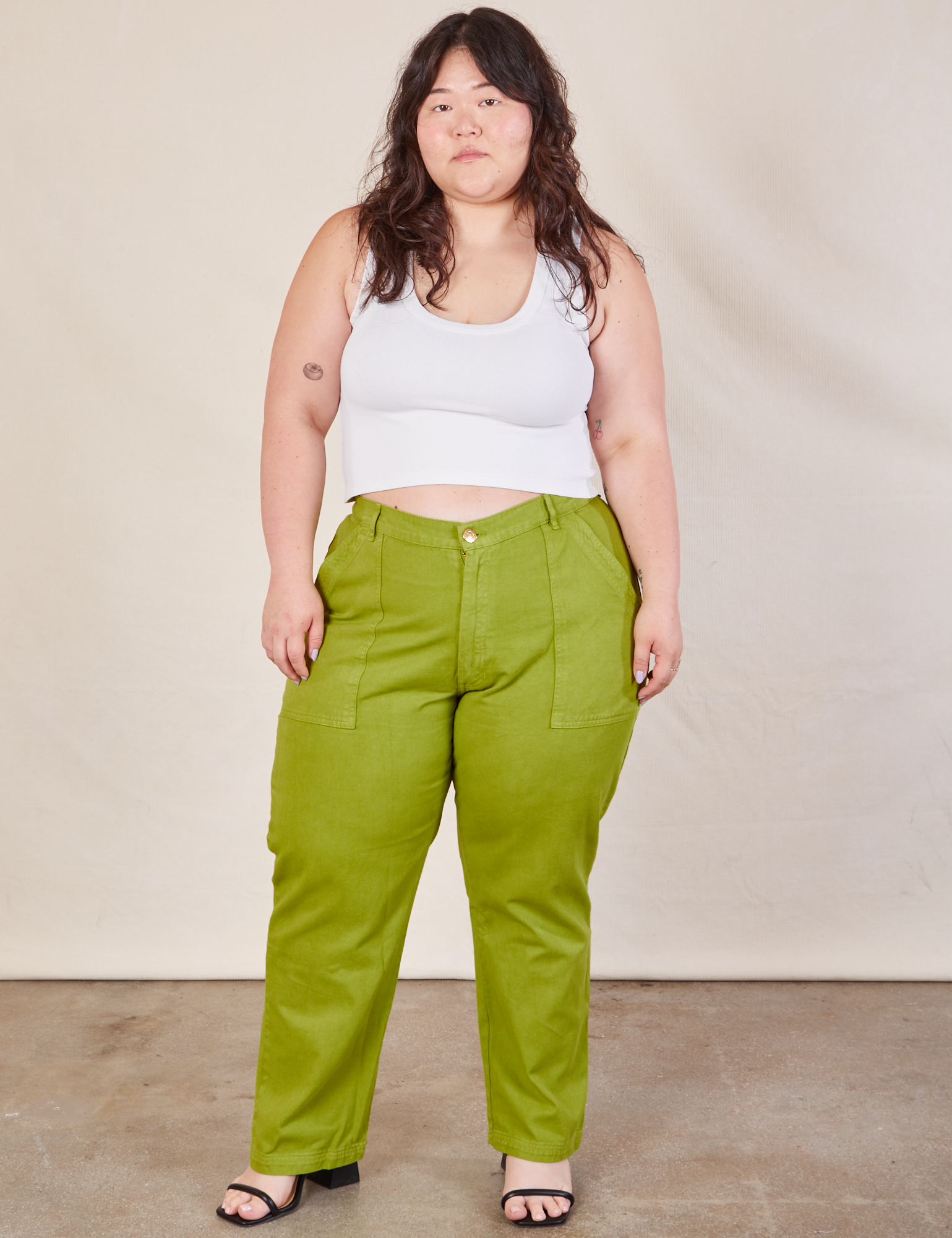 Ashley is 5&#39;7&quot; and wearing 1XL Work Pants in Gross Green paired with a Cropped Tank in vintage tee off-white