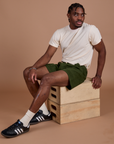 Isaac is wearing Classic Work Shorts in Evergreen and Organic Vintage Tee in Vintage Off-White