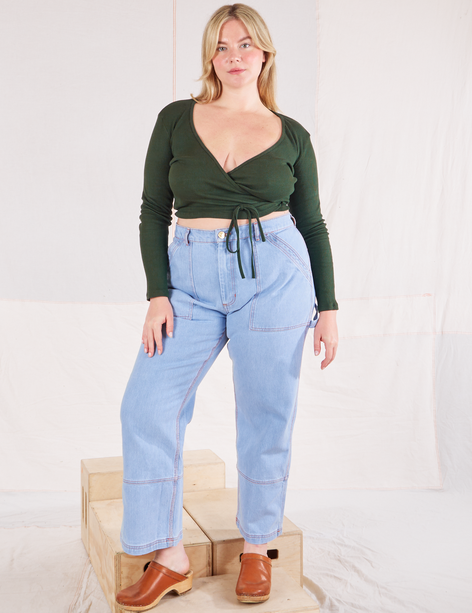 Lish is wearing Wrap Top in Swamp Green and light wash Carpenter Jeans