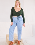 Lish is wearing Wrap Top in Swamp Green and light wash Carpenter Jeans