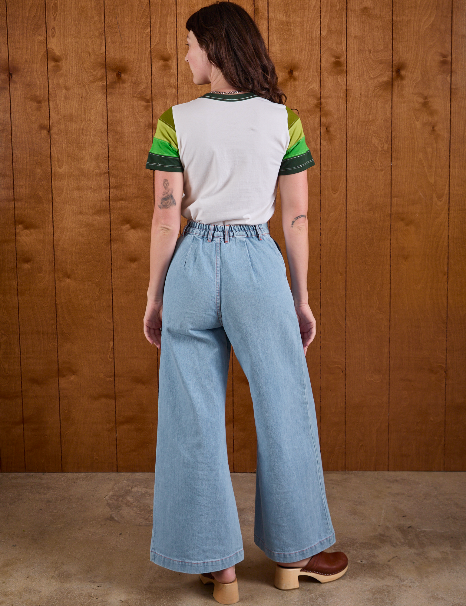 Back view of Calypso Tee in Forest and light wash Indigo Wide Leg Trousers on Alex