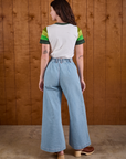 Back view of Calypso Tee in Forest and light wash Indigo Wide Leg Trousers on Alex