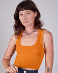 Alex is 5'8" and wearing P Cropped Tank Top in Creamsicle Orange