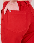 Close up of Alex's hand in the back pocket of Mid-Rise Work Pants in Mustang Red