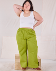 Ashley is 5'7" and wearing 1XL Action Pants in Gross Green paired with a Cropped Tank in Vintage Tee Off-White