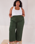 Morgan is wearing Action Pants in Swamp Green and Cropped Tank in vintage off-white. She has both hands in the pockets.