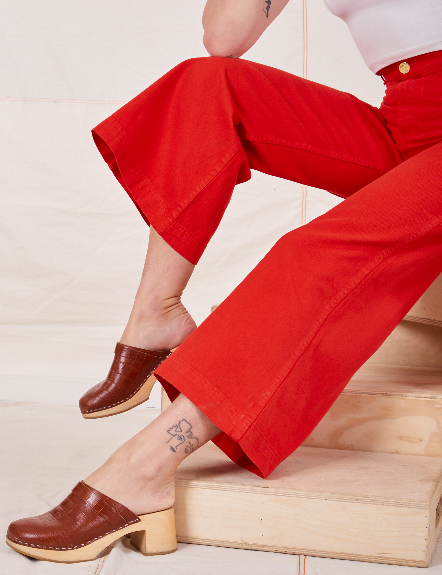 Bell Bottoms in Mustang Red pant leg close up on Alex