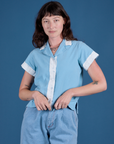 Alex is wearing a buttoned up Painted Pantry Button-Up in Baby Blue