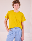 Quinn is wearing Burly Tee in Golden Yellow tucked into light wash Denim Wide Leg Trousers