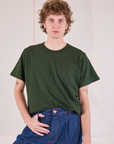 Quinn is wearing Burly Tee in Swamp Green tucked into dark wash Denim Wide Leg Trousers