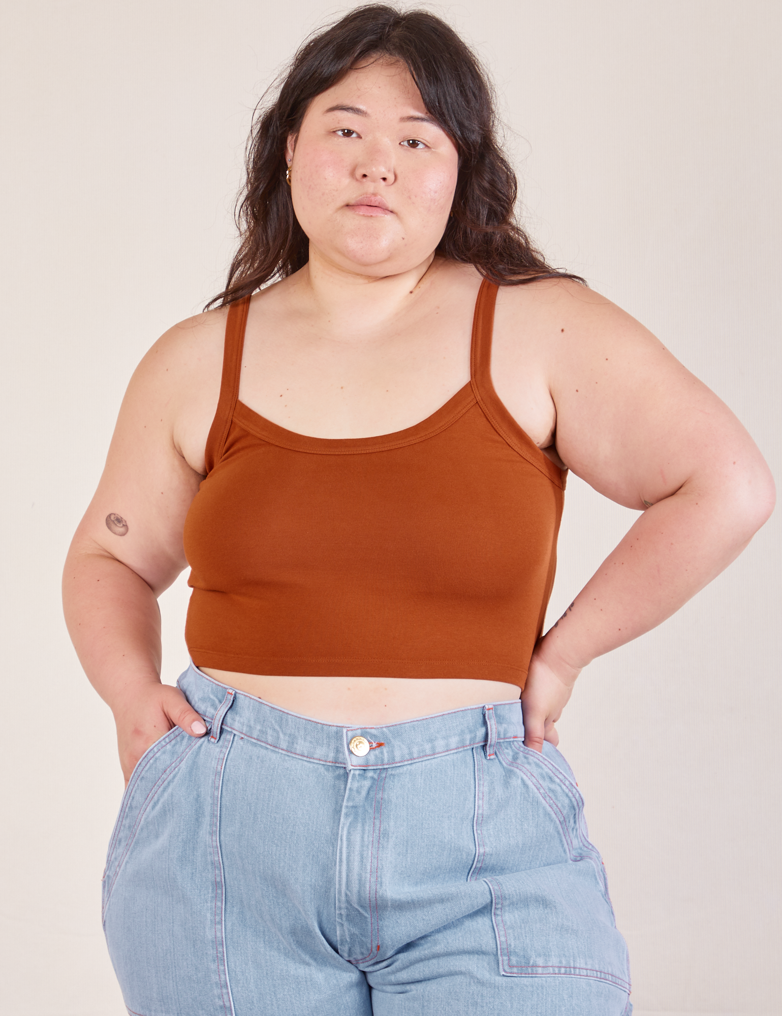 Ashley is 5’7” and wearing L Cropped Cami in Burnt Terracotta paired with light wash Carpenter Jeans