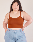 Ashley is 5’7” and wearing L Cropped Cami in Burnt Terracotta paired with light wash Carpenter Jeans