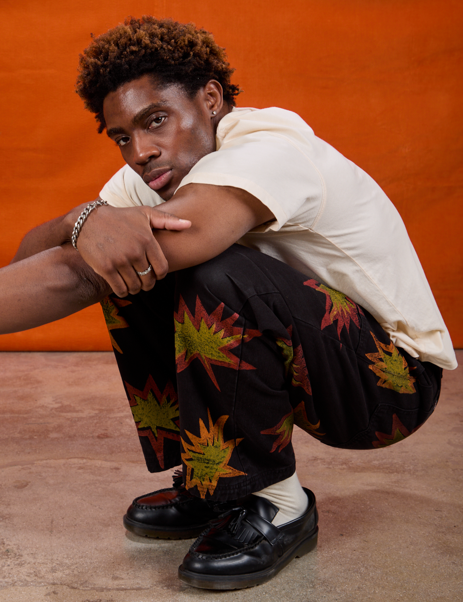 Isaac is wearing Paintstamped Work Pants in Explosion and Organic Vintage Tee in Vintage Tee Off-White