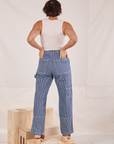 Back view of Carpenter Jeans in Railroad Stripes. Tiara has both her hands in the back pockets.